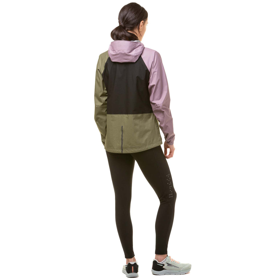 Back view of a model wearing a Ronhill Women's Tech Fortify Jacket in the Woodland/Stardust/Black. Model is also wearing black running tights and grey running shoes. (8024348328098)