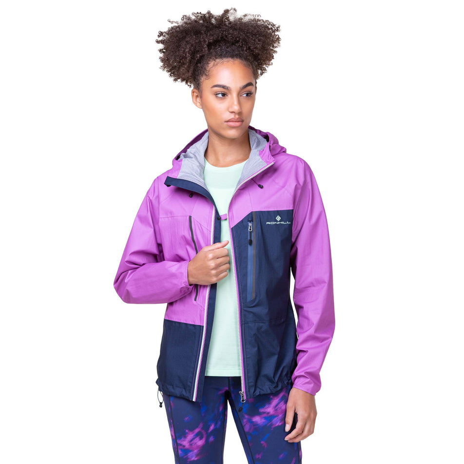 Front view of a model wearing the Women's Tech Fortify Jacket in the Dark Navy/Fuchsia colourway. Model is also wearing Ronhill leggings. (8160855752866)