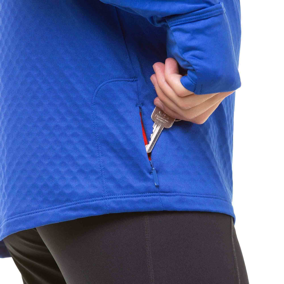 A model demonstrating that on the lower right side of a Ronhill Men's Tech Prism 1/2 Zip Tee - there is a zipped pocket for a key. (8032256393378)