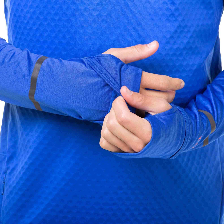 A model demonstrating that the ends of the sleeves - on a Ronhill Men's Tech Prism 1/2 Zip Tee - provide some coverage for the hands.  (8032256393378)