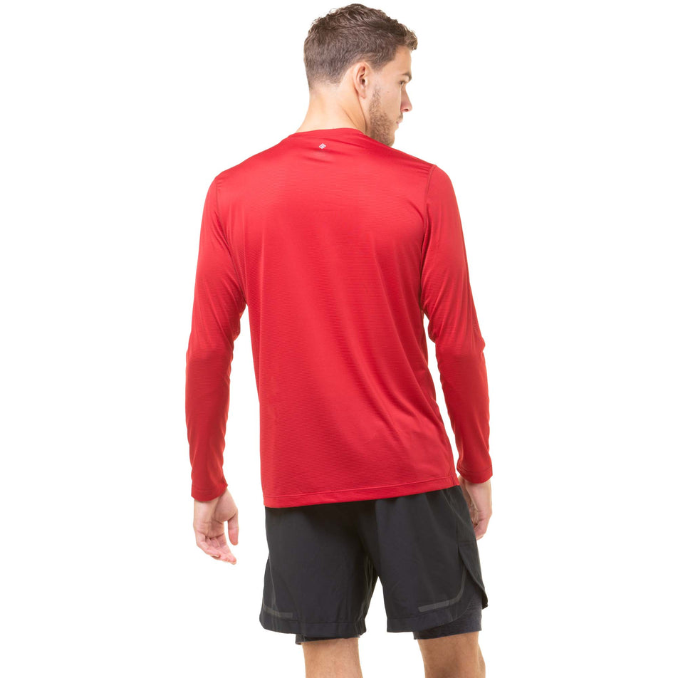 Back view of a model wearing a Ronhill Men's Tech L/S Tee in the Jam/Flame colourway. Model is also wearing Ronhill shorts. (8048653467810)