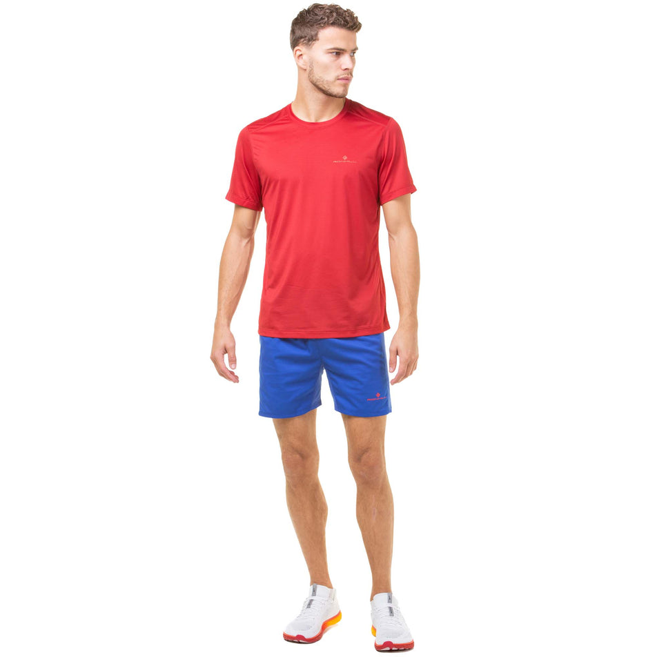 Front view of a model wearing a Ronhill Men's Tech S/S Tee in the Jam/Flame colourway. Model is also wearing a pair of Ronhill running shorts and Altra running shoes. (8048107978914)
