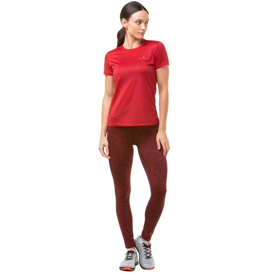 Front view of a model wearing a Ronhill Women's Tech S/S Tee in the Jam/Flame colourway. Model is also wearing Ronhill running leggings and Altra running shoes. (8047387181218)