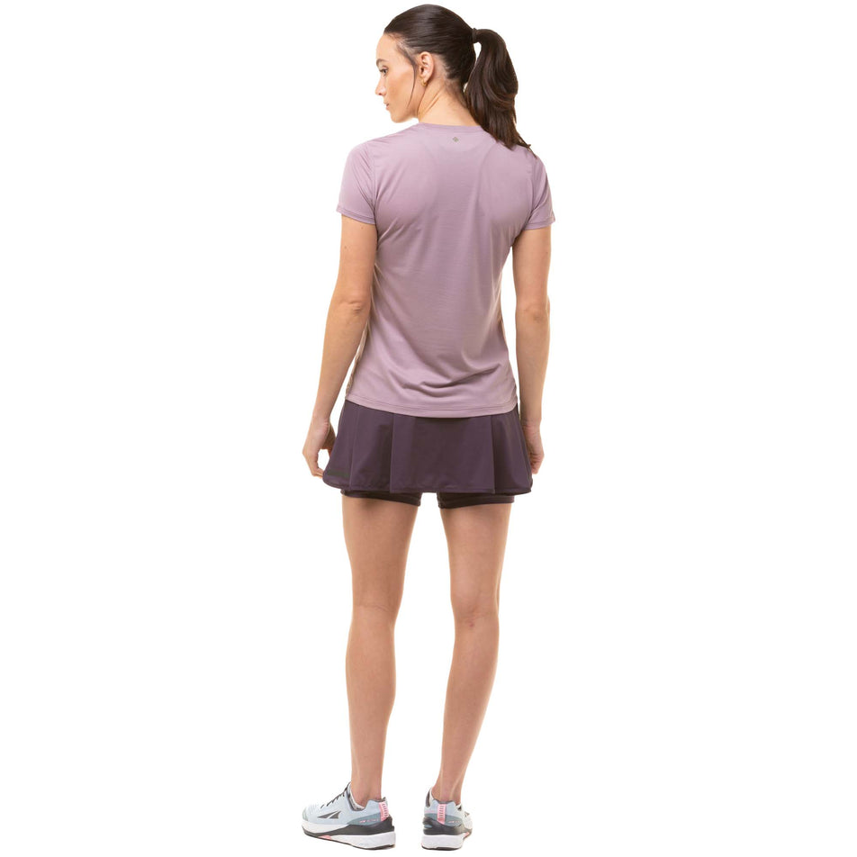 Back view of a model wearing a Ronhill Women's Tech S/S Tee in the Stardust/Woodland colourway. Model also wearing a Ronhill running skort and Altra running shoes. (8047373811874)