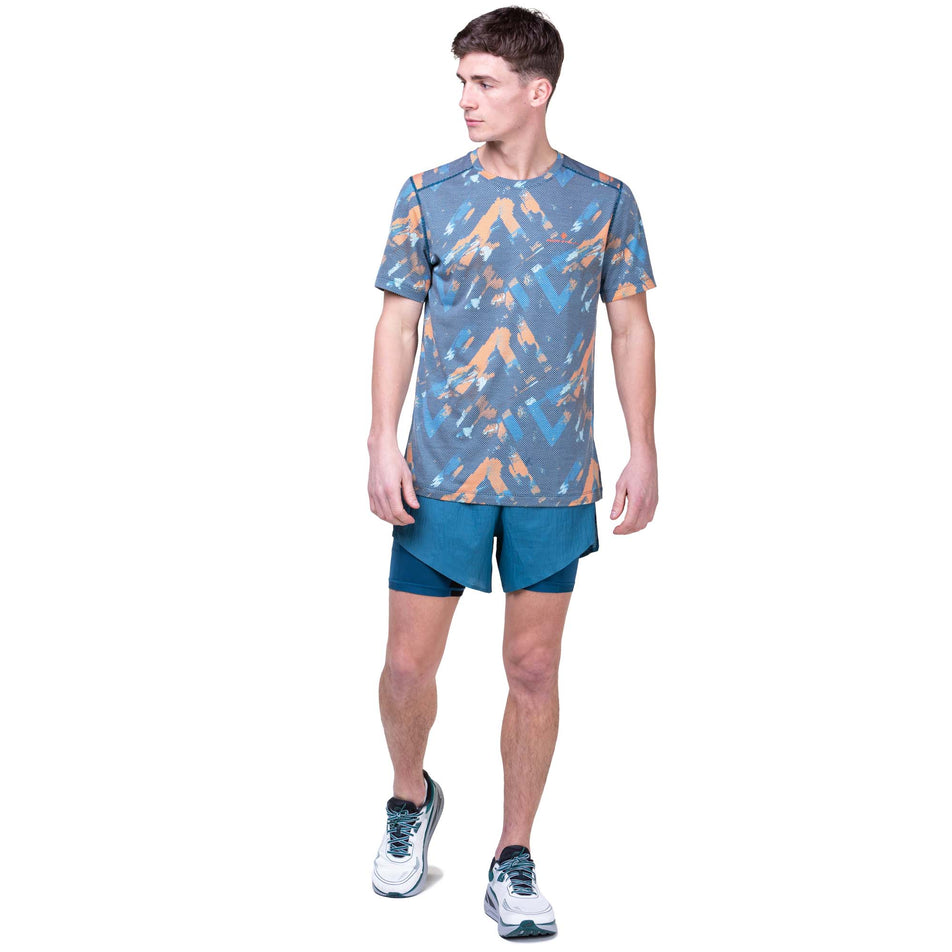 Front view of a model wearing the Ronhill Men's Tech Golden Hour Tee in the Legion Blue Chevron colourway. Model is also wearing Ronhill running shorts and Altra running shoes. (8159267422370)