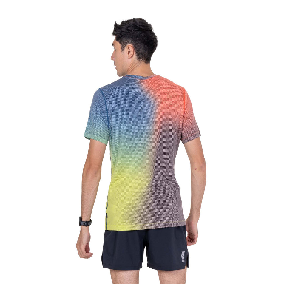 Back view of a model wearing the Ronhill Men's Tech Golden Hour S/S Tee in the Ronhill Red Merge colourway.