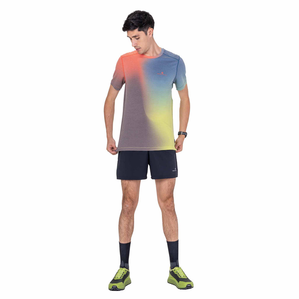 Front view of a model wearing the Ronhill Men's Tech Golden Hour S/S Tee in the Ronhill Red Merge colourway.