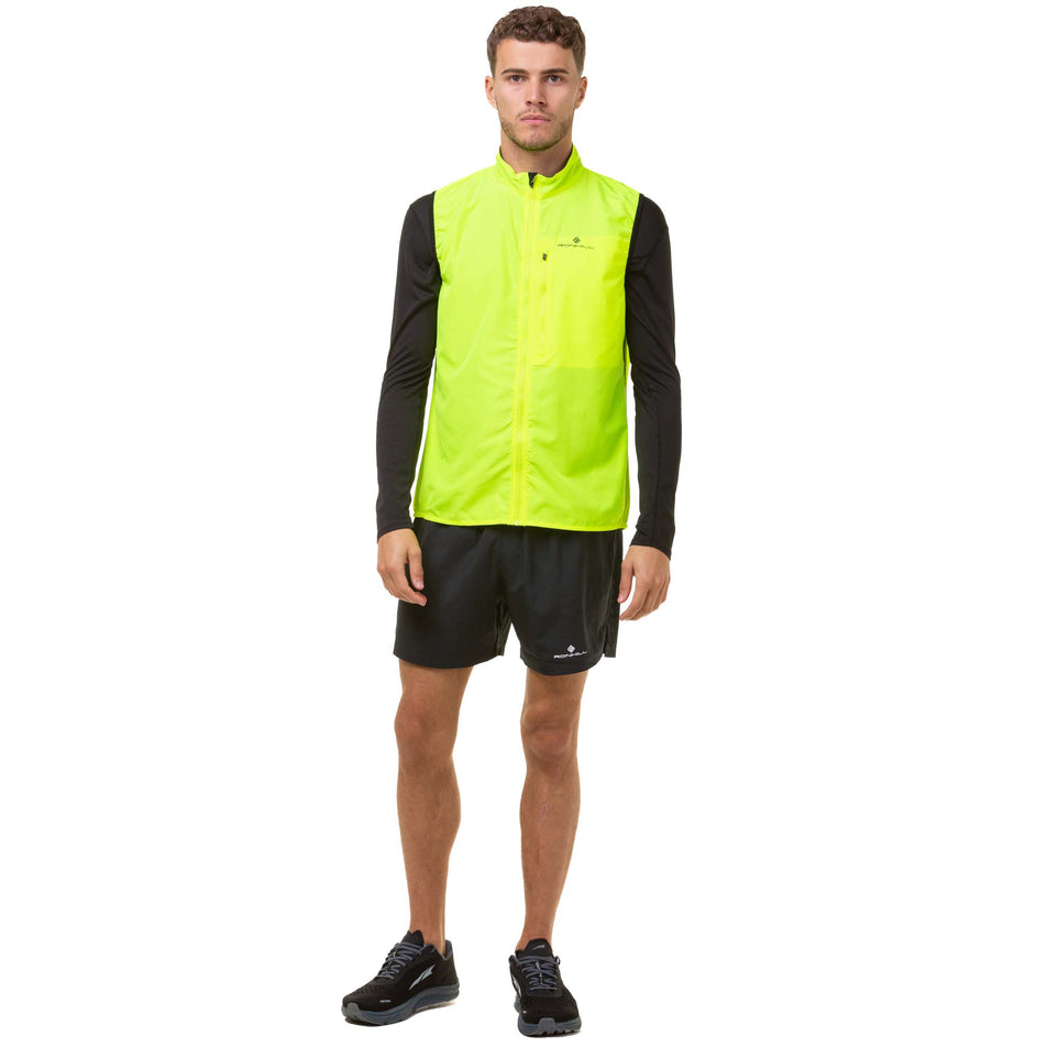 Front view of a model wearing a Ronhill Men's Core Gilet in the Fluo Yellow/Black colourway. Model is also wearing Ronhill running shorts and Altra running shoes. (8048132456610)
