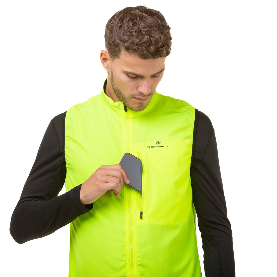 A model demonstrating that a phone can be stored in the chest pocket of a Ronhill Men's Core Gilet. (8048132456610)