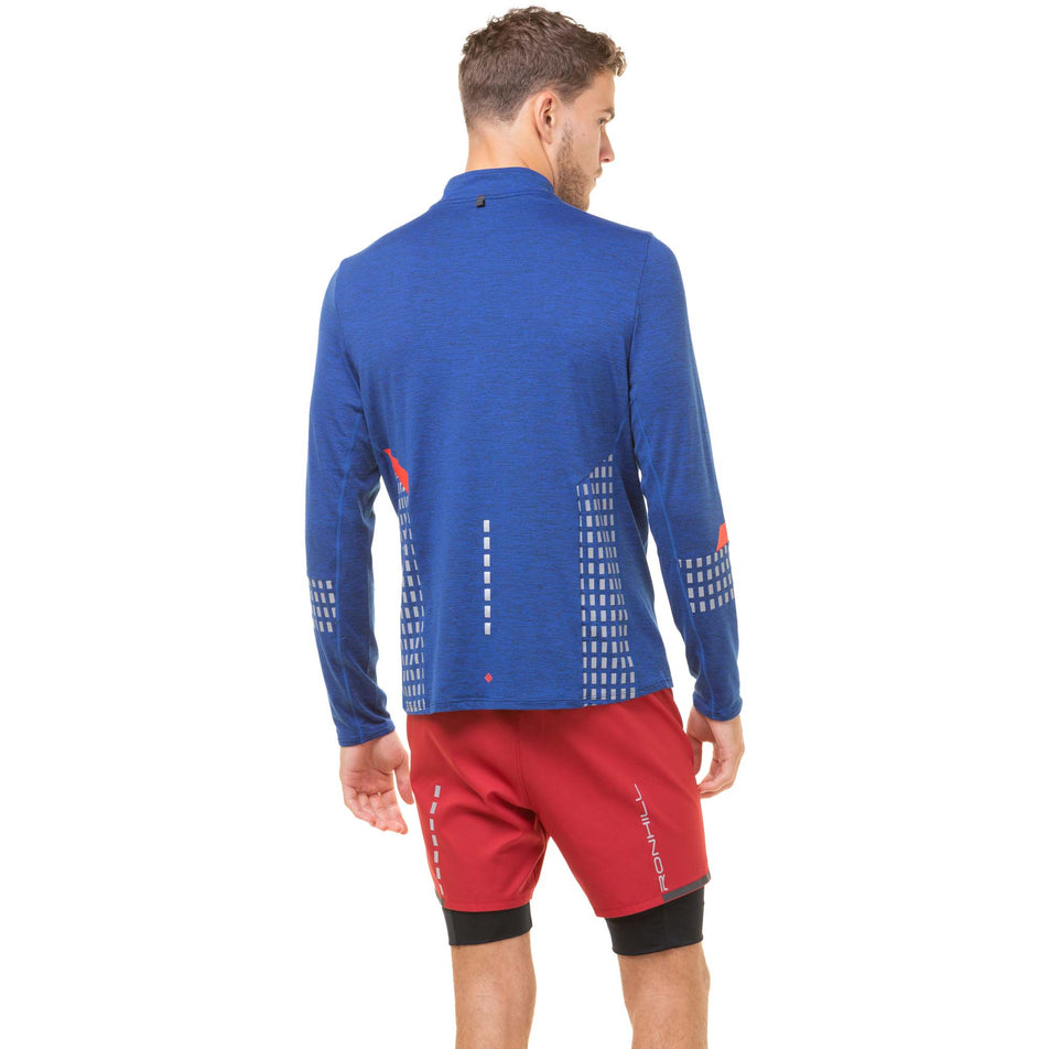 Back view of a model wearing a Ronhill Men's Tech Afterhours 1/2 Zip Tee in the Cobalt Marl/Flame/Reflect colourway. Model also wearing red Ronhill shorts.  (8032204390562)