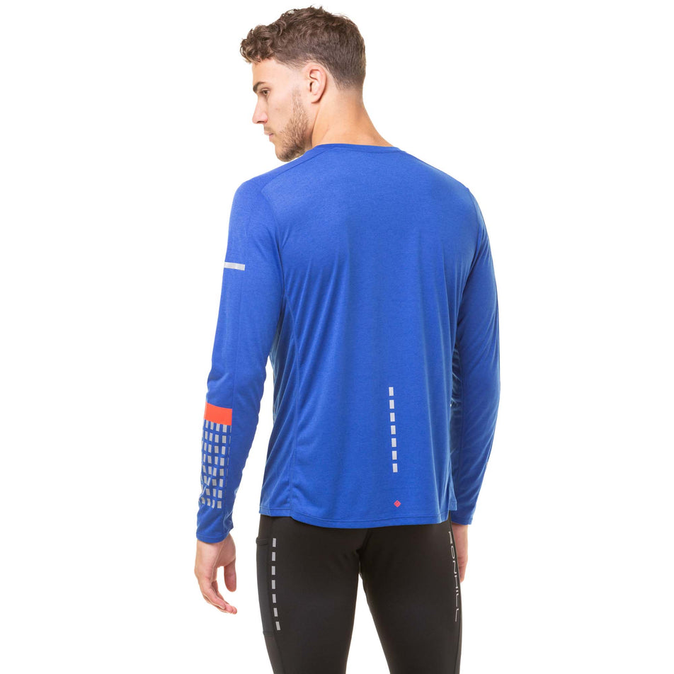 Back view of a model wearing a Ronhill Men's Tech Afterhours L/S Tee in the Cobalt/Flame/Reflect colourway. Model is also wearing Ronhill running tights. (8047874408610)