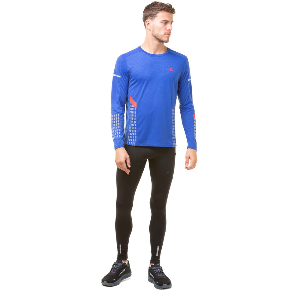 Front view of a model wearing a Ronhill Men's Tech Afterhours L/S Tee in the Cobalt/Flame/Reflect colourway. Model is also wearing Ronhill running tights and Altra running shoes. (8047874408610)