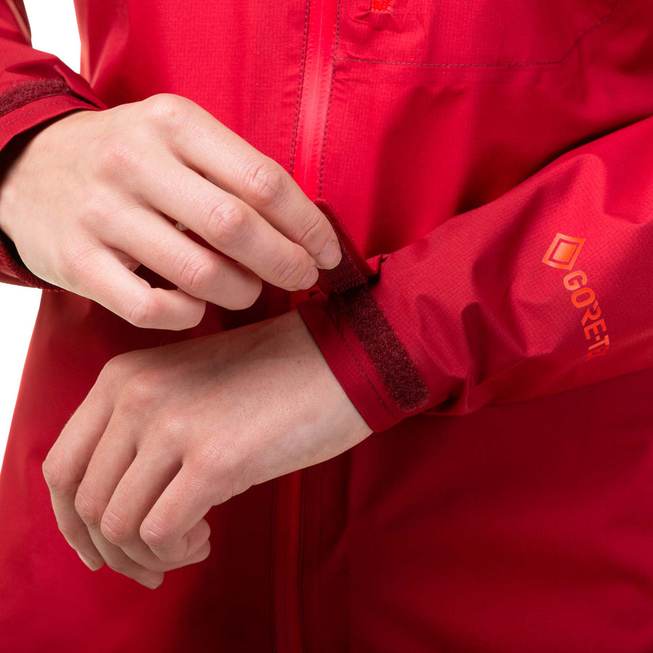 A model demonstrating that, on a Ronhill Women's Tech GORE-TEX Mercurial Jacket, the ends of the sleeves can be adjust via the velcro tabs. (8047328034978)