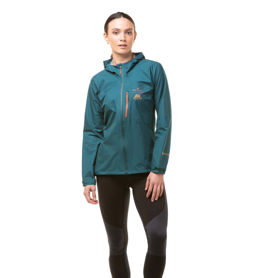Front view of a model wearing a Ronhill Women's Tech Gore-Tex Mercurial Jacket in the Deep Lagoon/Copper colourway. Model is also wearing Ronhill running leggings. (8059839119522)