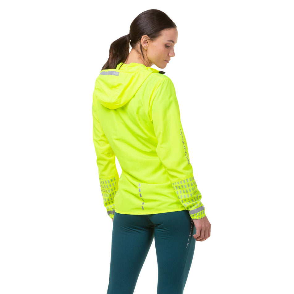 Back view of a model wearing a Ronhill Women's Tech Afterhours Jacket in the Fluo Yellow/Deep Lagoon/Reflect colourway. (8019130286242)