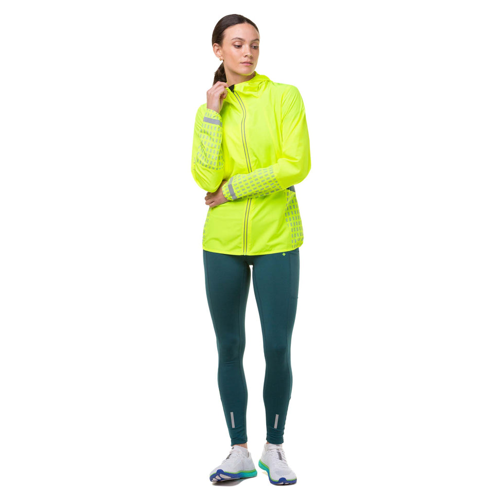 Front view of a model wearing a Ronhill Women's Tech Afterhours Jacket in the Fluo Yellow/Deep Lagoon/Reflect colourway. (8019130286242)