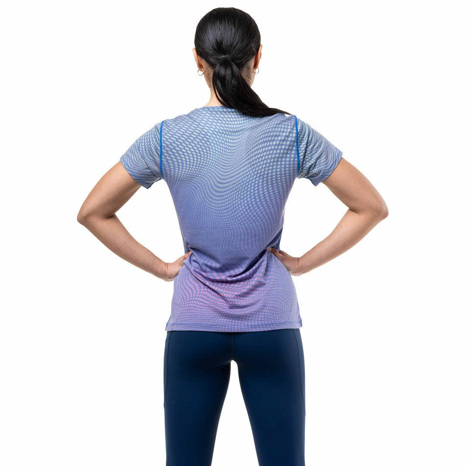 Back view of a model wearing the Ronhill Women's Tech Golden Hour S/S Tee in the Classic Blue Refraction colourway.