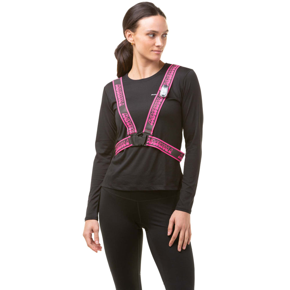 Front view of a model wearing a Ronhill Reflective Belt in the Fluo Pink colourway. Model is also wearing a Ronhill running top, Ronhill running leggings and a Ronhill light. (8048568729762)