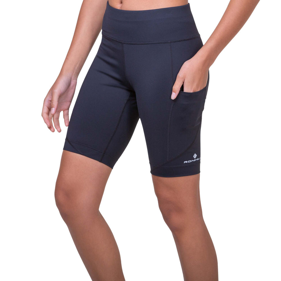 Front view of a model wearing the Ronhill Women's Tech Stretch Short in the Black/Bright White colourway (8158822564002)