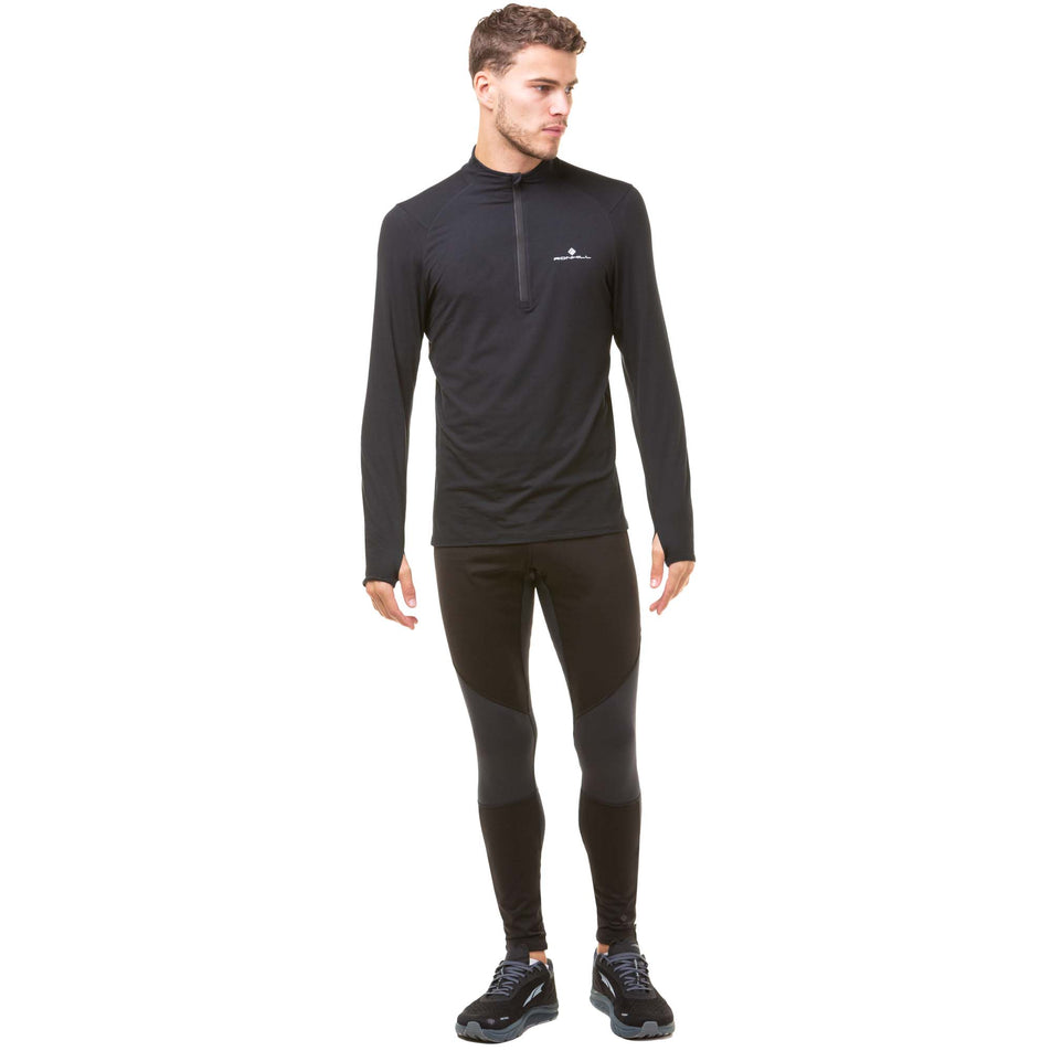 Front view of model wearing a Ronhill Men's Core Thermal 1/2 Zip in the Black/Bright White colourway. Model is also wearing black Ronhill running tights and Altra running shoes. (8032268517538)