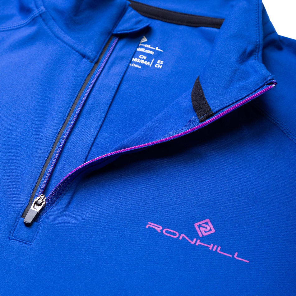 Close-up front view of the zip detail and Ronhill logo on a Ronhill Women's Core Thermal 1/2 Zip in the Cobalt/Thistle colourway (8032082264226)