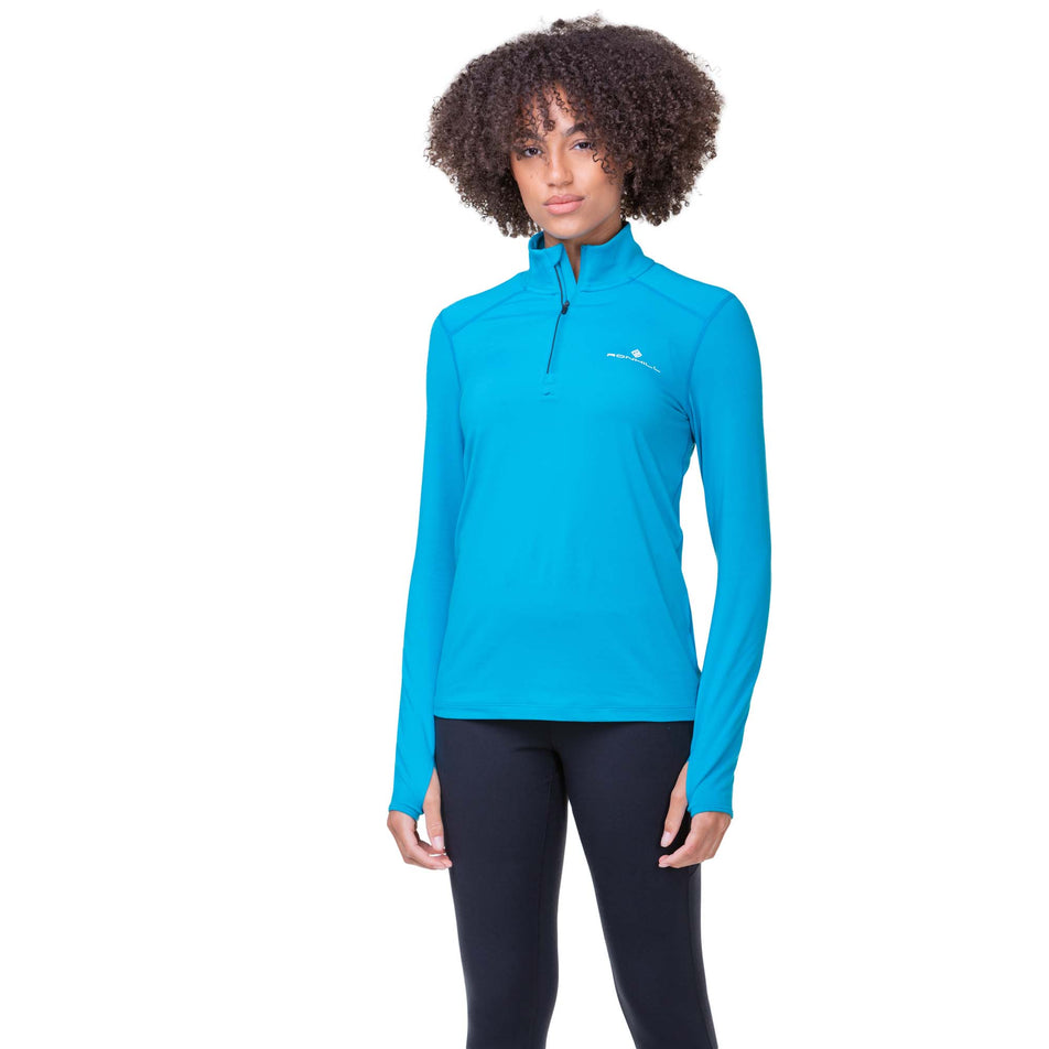 Front view of a model wearing a Ronhill Women's Core Thermal 1/2 Zip in the Azure/Bright White colourway. Model is also wearing Ronhill leggings. (8159242813602)