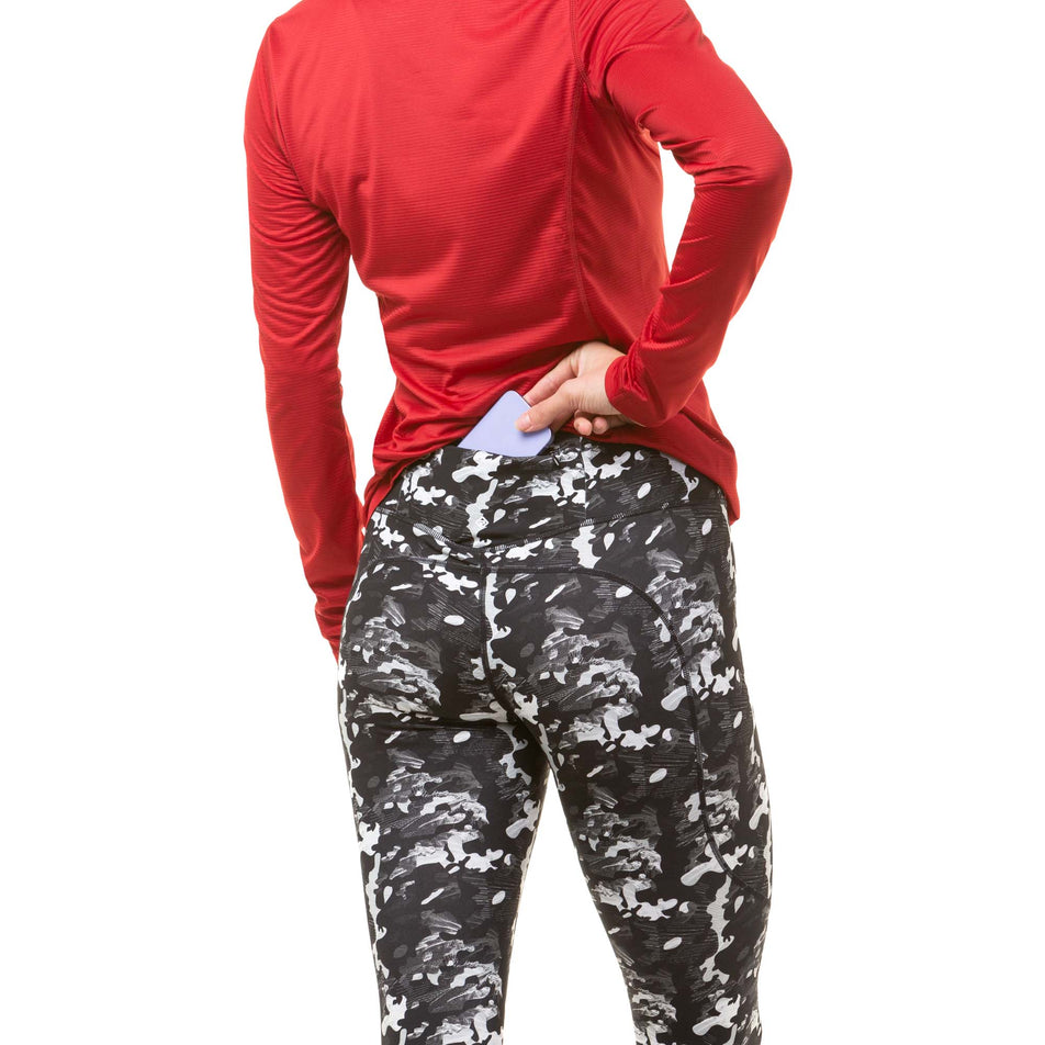 A model demonstrating that a mobile phone can be stored in the zipped back pocket of a pair of Ronhill Women's Tech Tights (8047451832482)