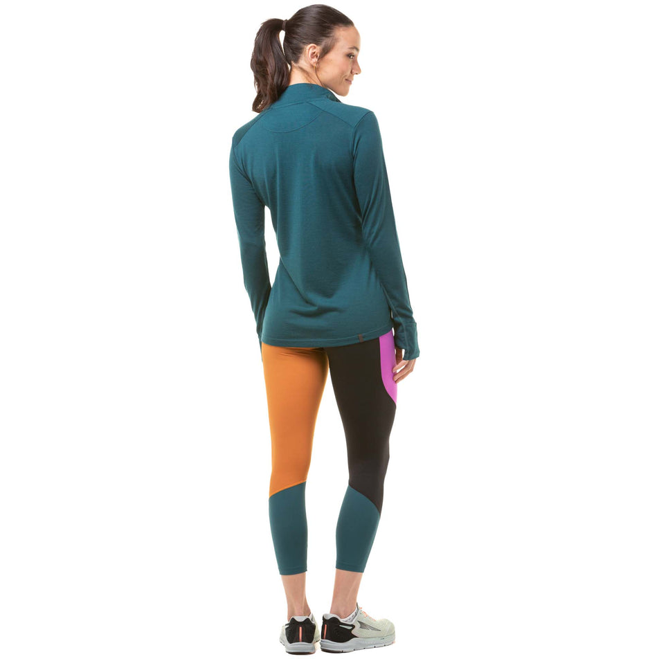 Back view of a model wearing a pair of Ronhill Women's Tech Crop Tights in the Deep Lagoon/Thistle colourway. Model is also wearing a Ronhill running top and a pair of Altra running shoes. (8047461793954)