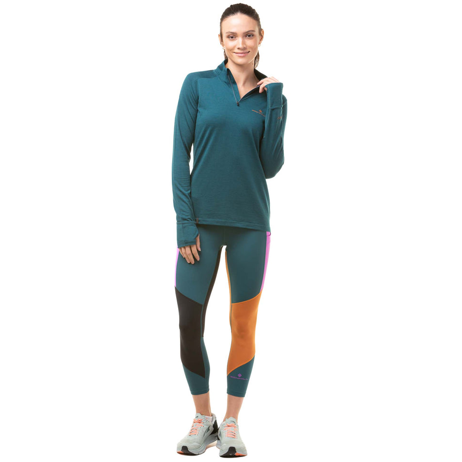 Front view of a model wearing a pair of Ronhill Women's Tech Crop Tights in the Deep Lagoon/Thistle colourway. Model is also wearing a Ronhill running top and a pair of Altra running shoes. (8047461793954)