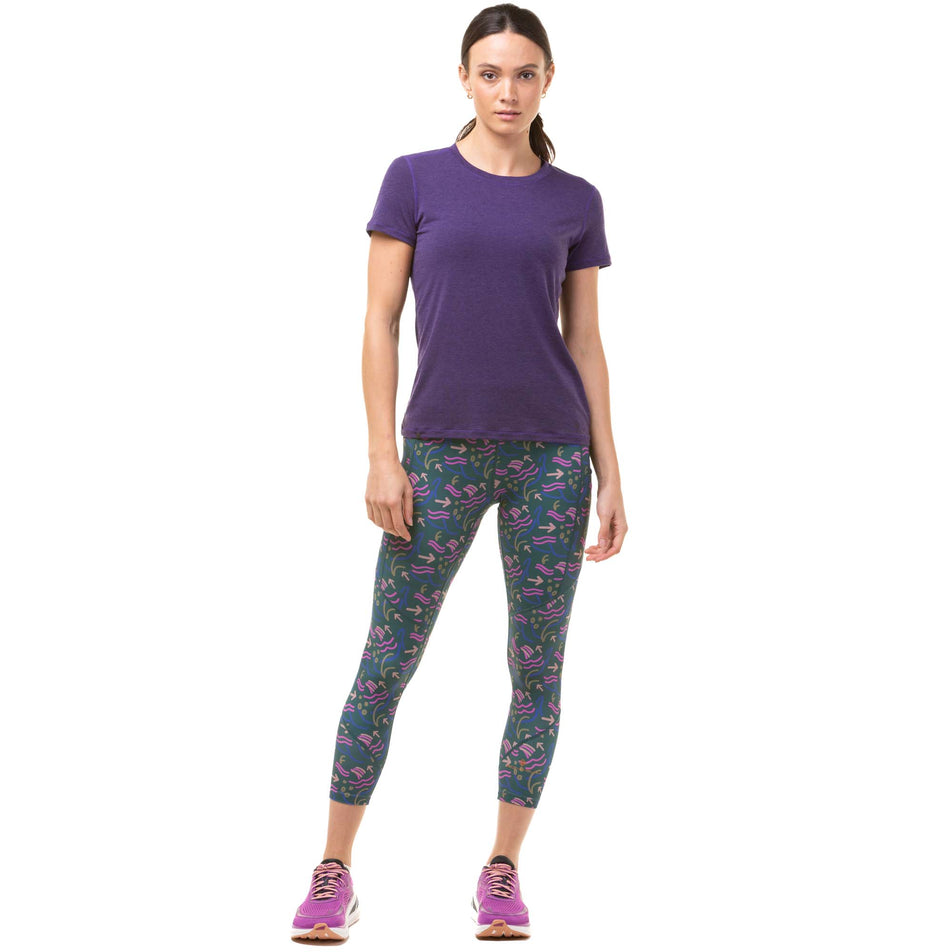 Front view of a model wearing a pair of Ronhill Women's Tech Crop Tights in the Deep Lagoon Direction colourway. Model is also wearing a Ronhill running t-shirt and Altra running shoes. (8047471526050)