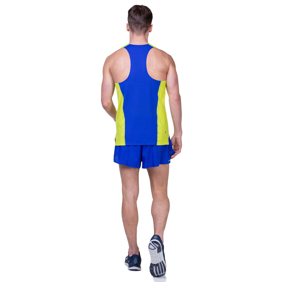 Back view of a model wearing the Ronhill Men's Tech Race Vest in the Citrus/Azurite colourway. Model is also wearing Ronhill shorts and Altra running shoes. (8159247171746)
