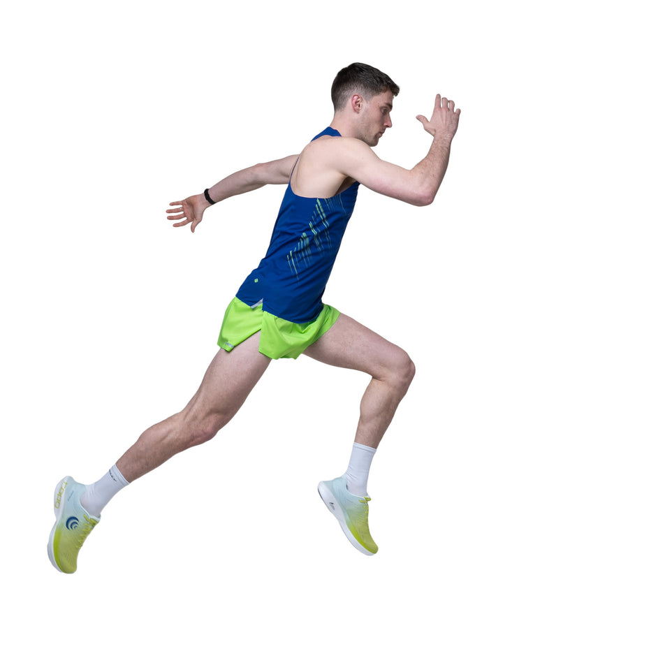 Side view of a model wearing the Ronhill Men's Tech Race Vest in the Dark Cobalt/Fluo Green colourway.