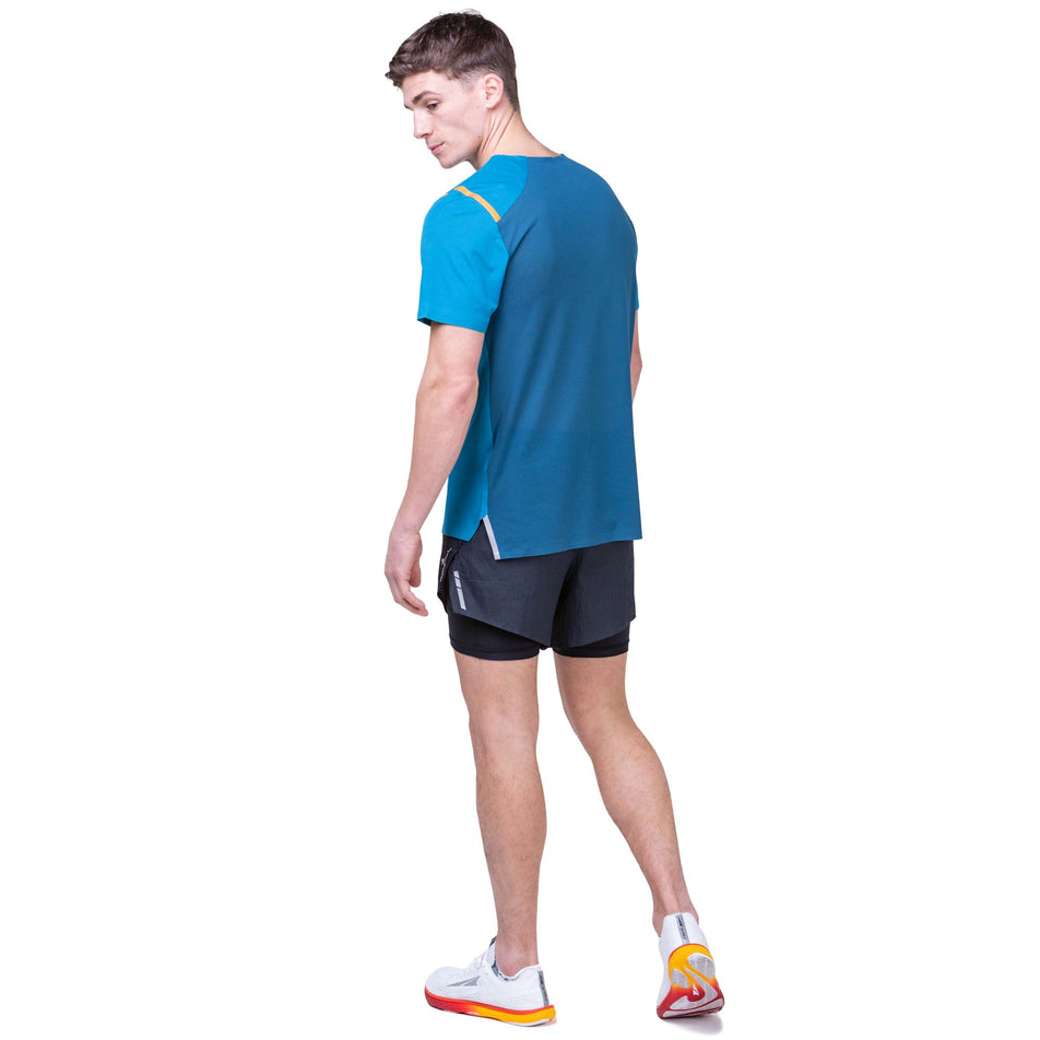 Back view of a model wearing the Ronhill Men's Tech Race S/S Tee in the Petrol/Legion Blue colourway. Model is also wearing Ronhill shorts. (8160876757154)