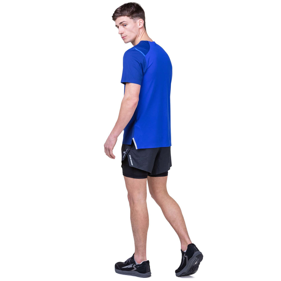 Back view of a model wearing a Ronhill Men's Tech Race S/S Tee in the Ocean/Azurite colourway. Model is also wearing Ronhill shorts and Altra running shoes. (8159262146722)