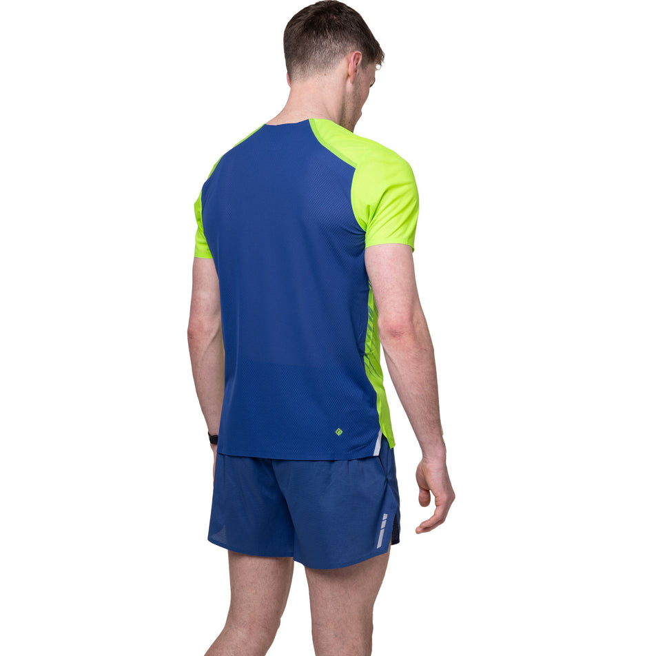 Back view of a model wearing the Ronhill Men's Tech Race S/S Tee in the Fluo Green/Dark Cobalt colourway.
