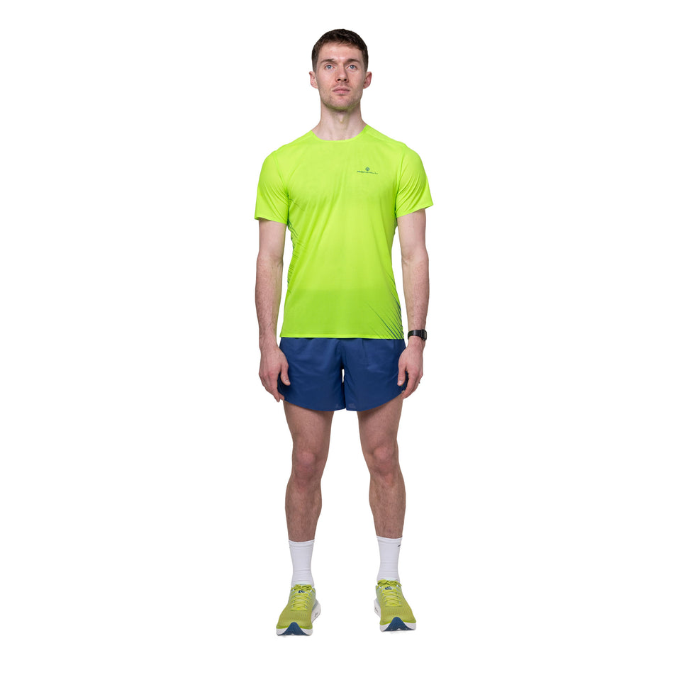 Front view of a model wearing the Ronhill Men's Tech Race S/S Tee in the Fluo Green/Dark Cobalt colourway.