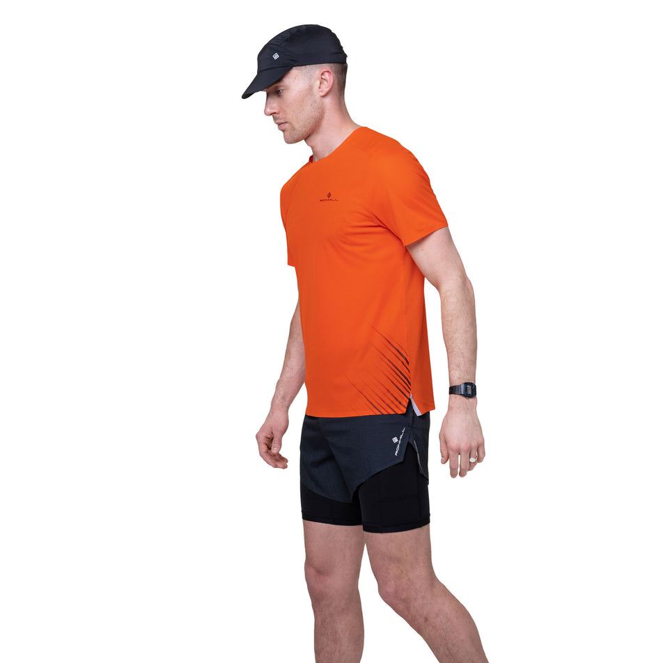 Angled view of a model wearing the Ronhill Men's Tech Race S/S Tee in the Ronhill Red/Black colourway.