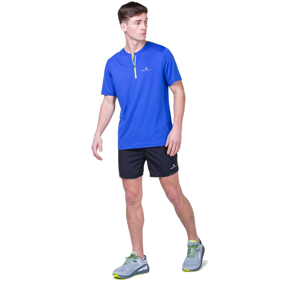 Front view of a model wearing the Ronhill Men's Tech 1/2 Zip S/S Tee in the Azurite/Citrus colourway. Model is also wearing Ronhill shorts and Altra running shoes. (8160879640738)