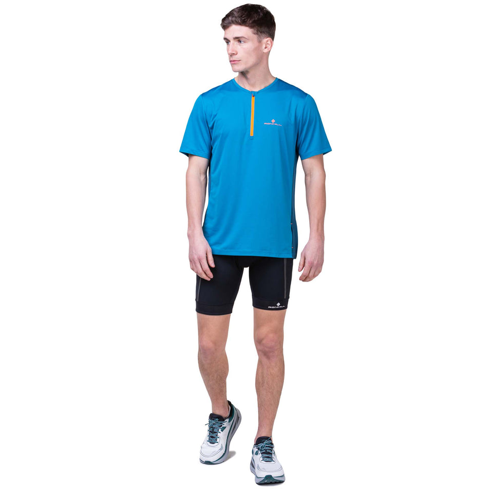 Front view of a model wearing the Ronhill Men's Tech 1/2 Zip S/S Tee in the Petrol/Fluo Orange colourway. Model is also wearing Ronhill shorts and Altra running shoes.  (8160879935650)