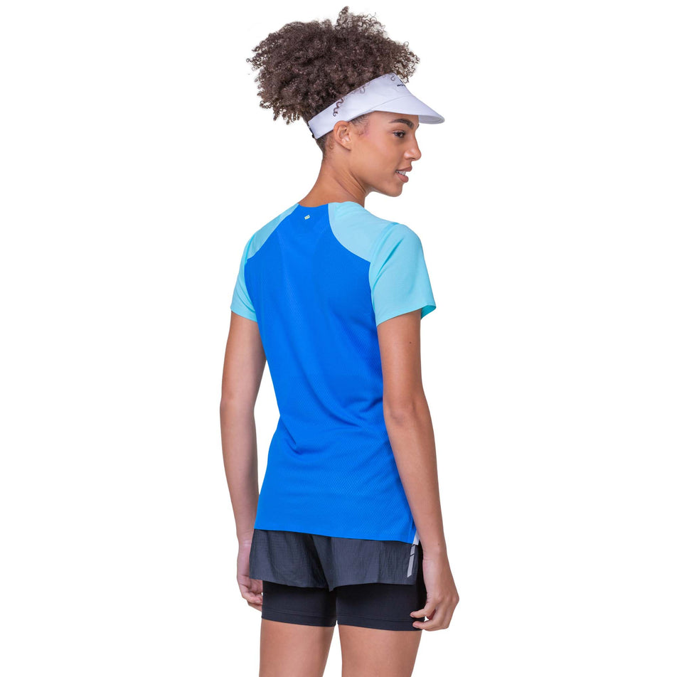 Back view of a model wearing a Ronhill Women's Tech Race S/S Tee in the Aquamint/Electric Blue colourway. Model is also wearing Ronhill running shorts. (8158807326882)