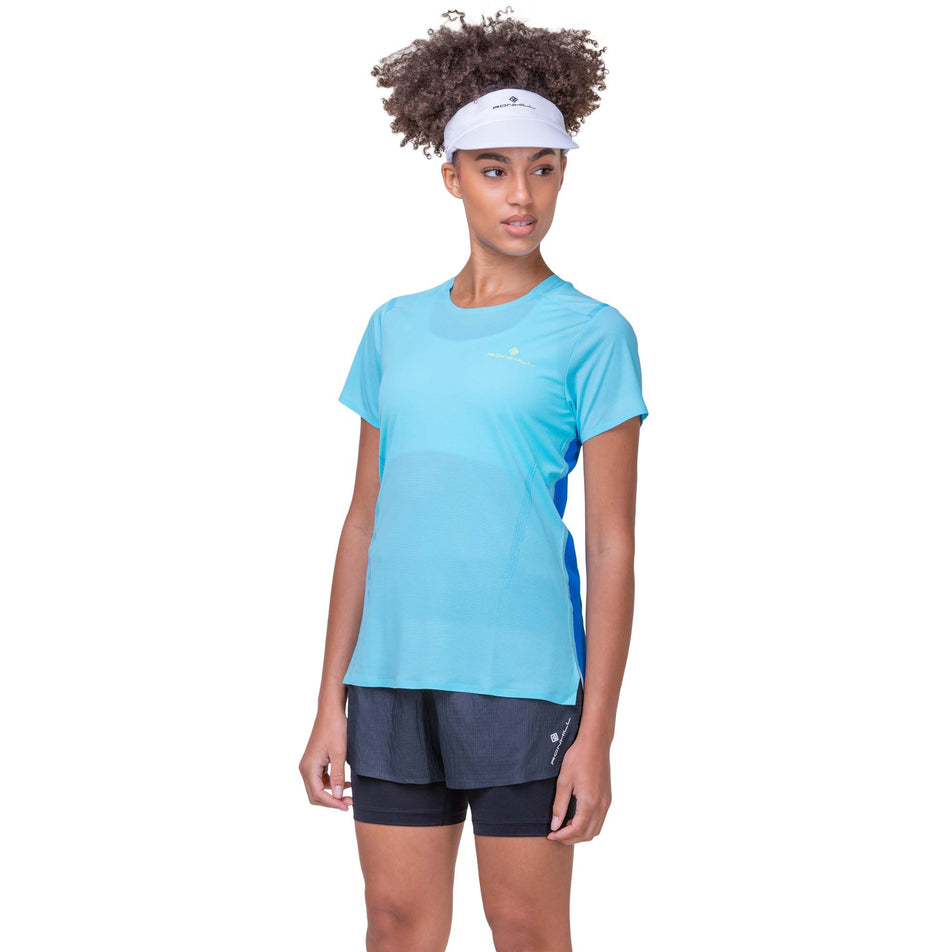 Front view of a model wearing a Ronhill Women's Tech Race S/S Tee in the Aquamint/Electric Blue colourway. Model is also wearing Ronhill running shorts. (8158807326882)