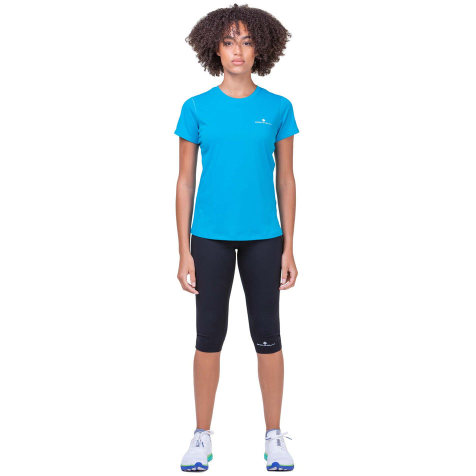 Front view of a model wearing a Ronhill Women's Core S/S Tee in the Azure/Bright White colourway. Model is also wearing Ronhill capris and Altra running shoes (8159237177506)