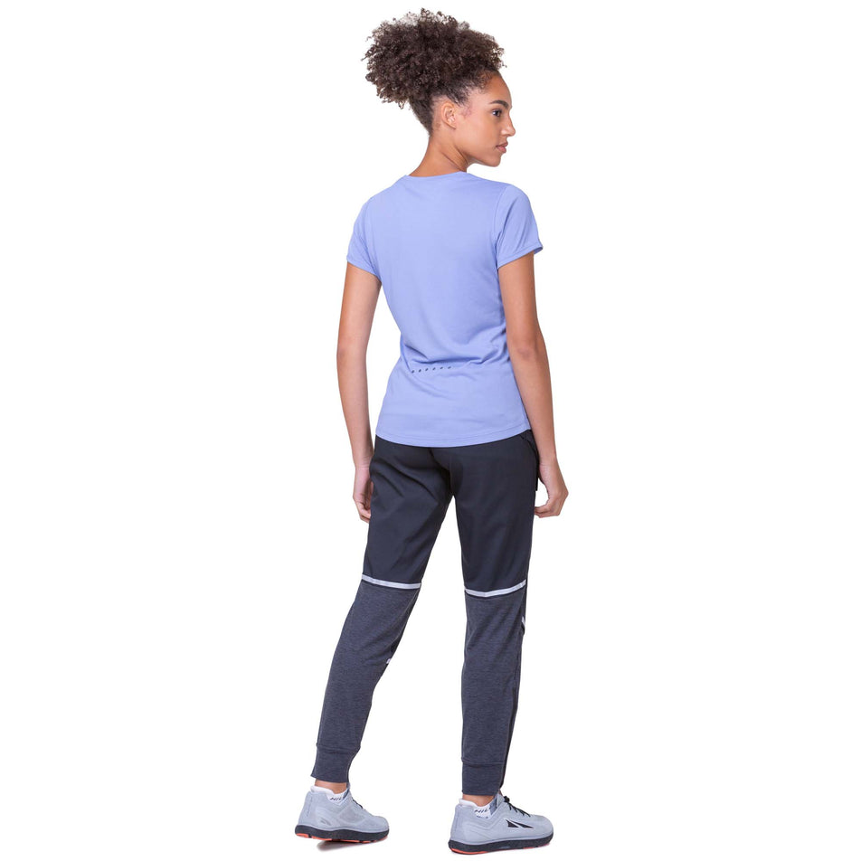 Back view of a model wearing a Ronhill Women's Core S/S Tee in the Periwinkle/Aquamint colourway. Model is also wearing Ronhill running trousers and Altra running shoes. (8159241437346)