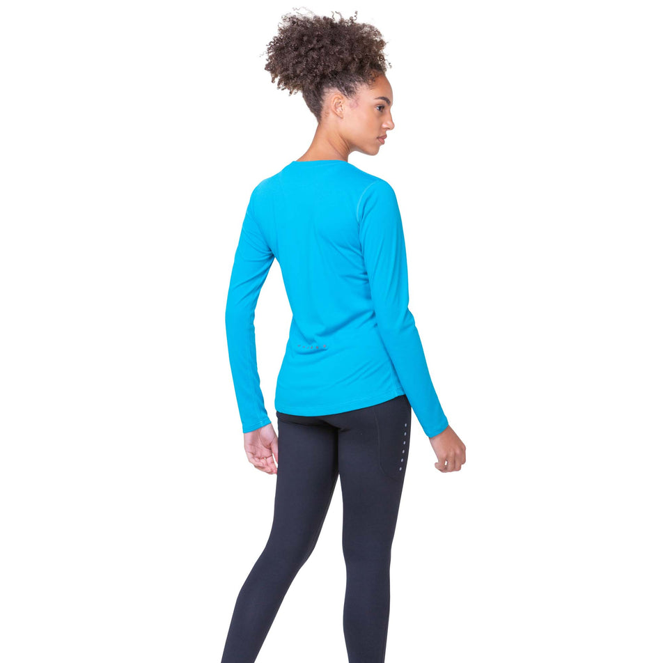 Back view of a model wearing a Ronhill Women's Core L/S Tee in the Azure/Bright White colourway. Model is also wearing Ronhill leggings. (8159242420386)