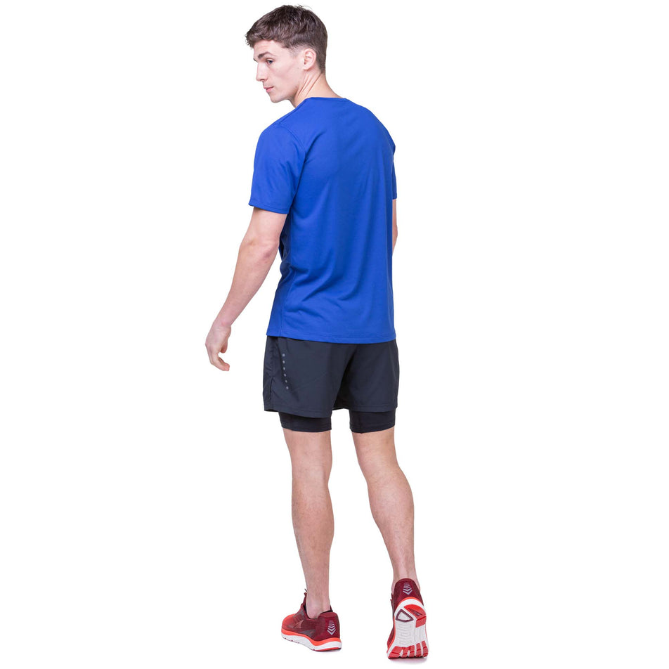 Back view of a model wearing the Ronhill Men's Core Twin Short in the All Black colourway. Model is also wearing a Ronhill t-shirt and Altra running shoes. (8159280201890)