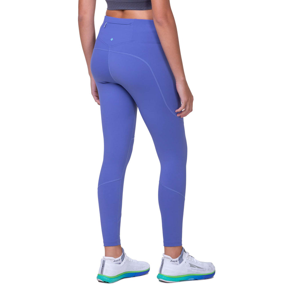 Back view of a model wearing the Ronhill Women's Tech Tight in the Dark Periwinkle/Aquamint colourway. Model us also wearing a Ronhill top and Altra running shoes. (8158835572898)