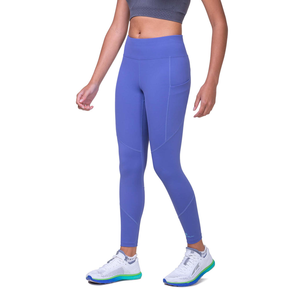 Front view of a model wearing the Ronhill Women's Tech Tight in the Dark Periwinkle/Aquamint colourway. Model us also wearing a Ronhill top and Altra running shoes. (8158835572898)