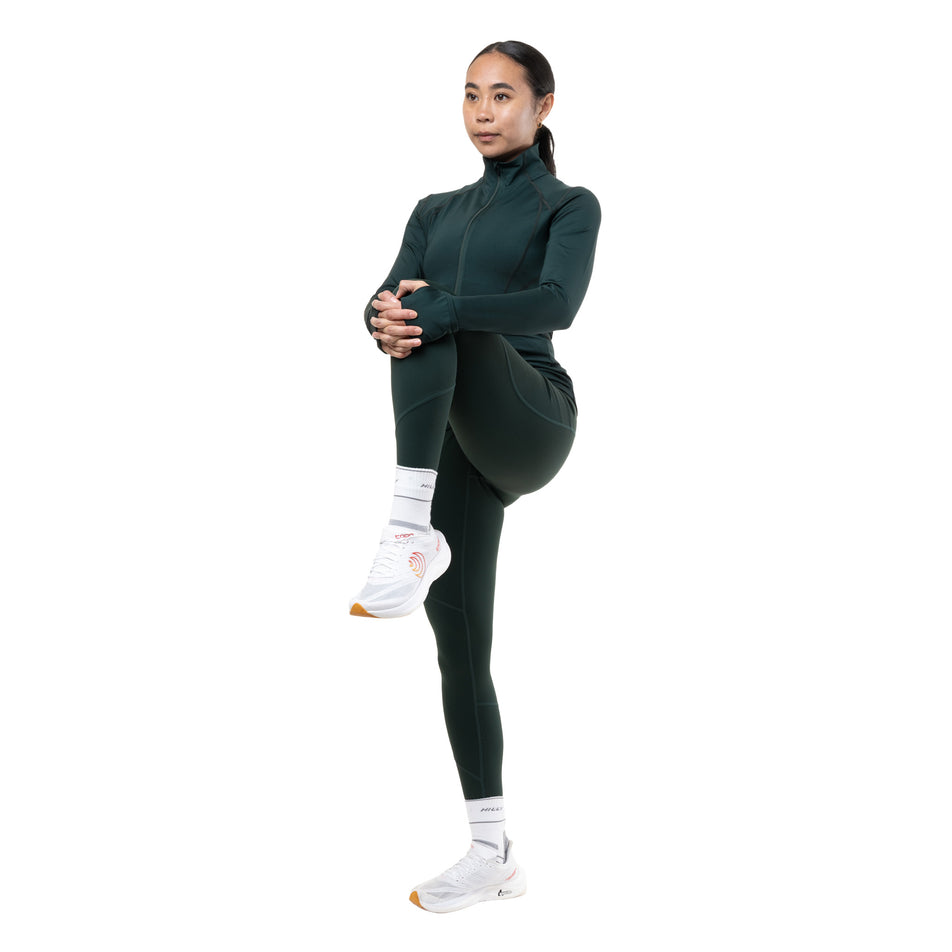 Angled view of a model wearing the Ronhill Women's Tech Tight in the Dark Laurel colourway.