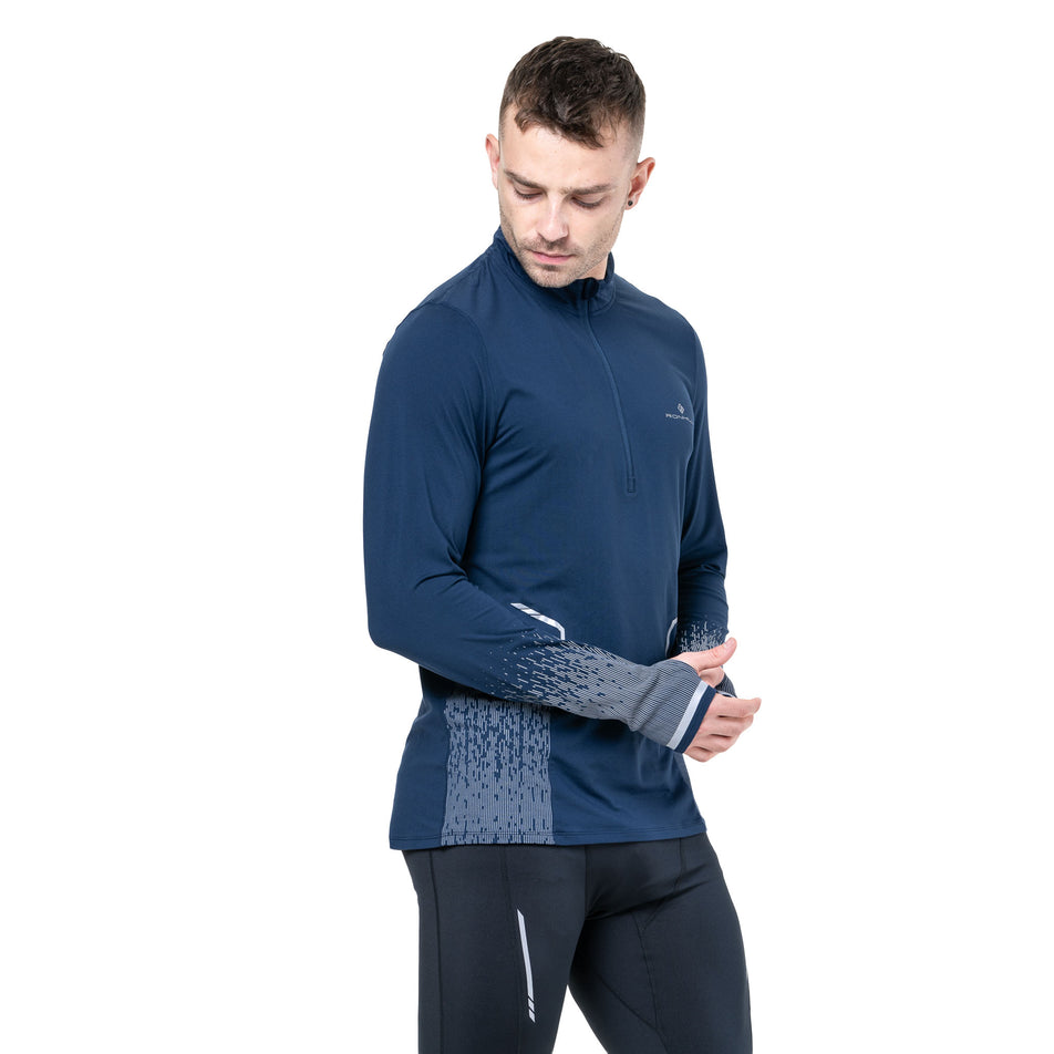Front view of a model wearing the Ronhill Men's Tech Reflect 1/2 Zip in the Dark Navy/Reflect colourway. (8742775455906)