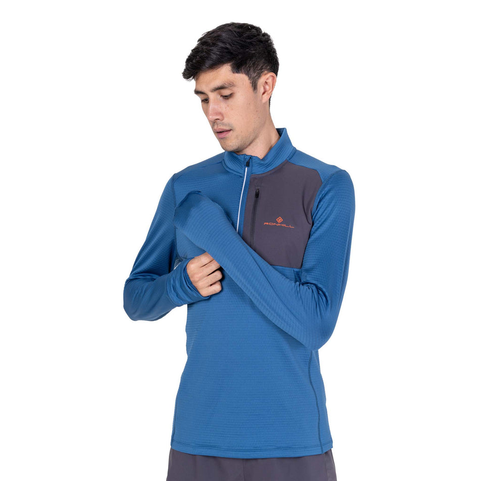 Front view of a model wearing the Ronhill Men's Tech Winter 1/2 Zip in the Glacier/Oxide colourway.